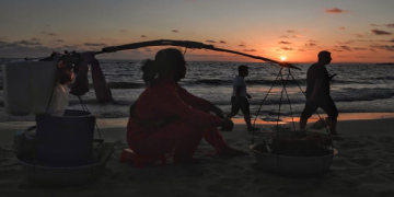 his picture taken on February 14, 2020 shows a food vendor waiting for customers as tourists walk along a beach in Sihanoukville. Tan Chhin Sothy | AFP | Getty Images